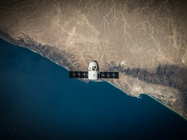 Satelitt som flyr over en planet, fotografert fra verdensrommet